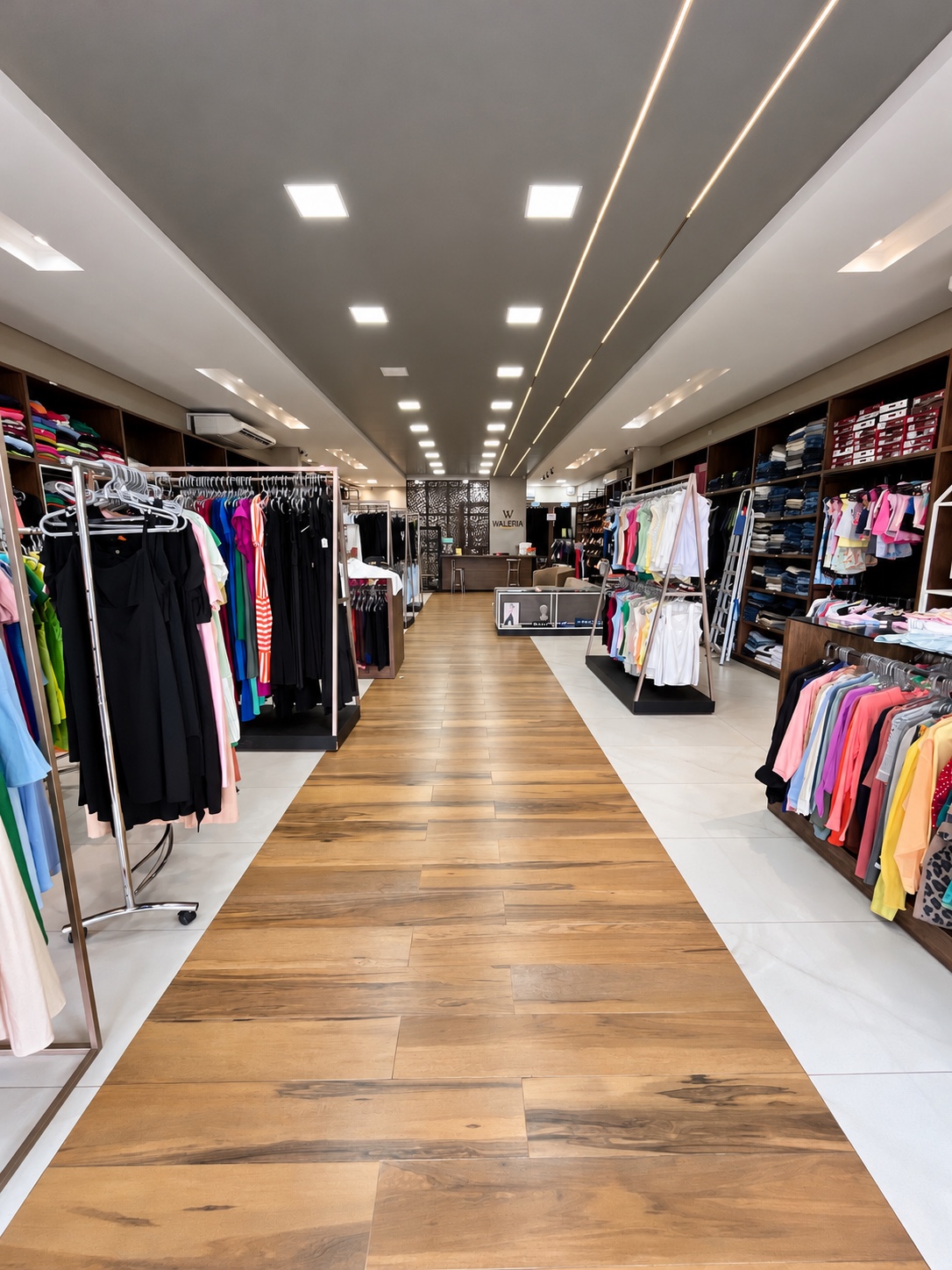 Interior da Waléria Modas com corredores e araras de roupas organizadas